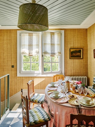 The tongueandgroove ceiling in Farrow  Balls ‘Light Blue sets off a raffia wallcovering from Phillip Jeffries. Chairs...